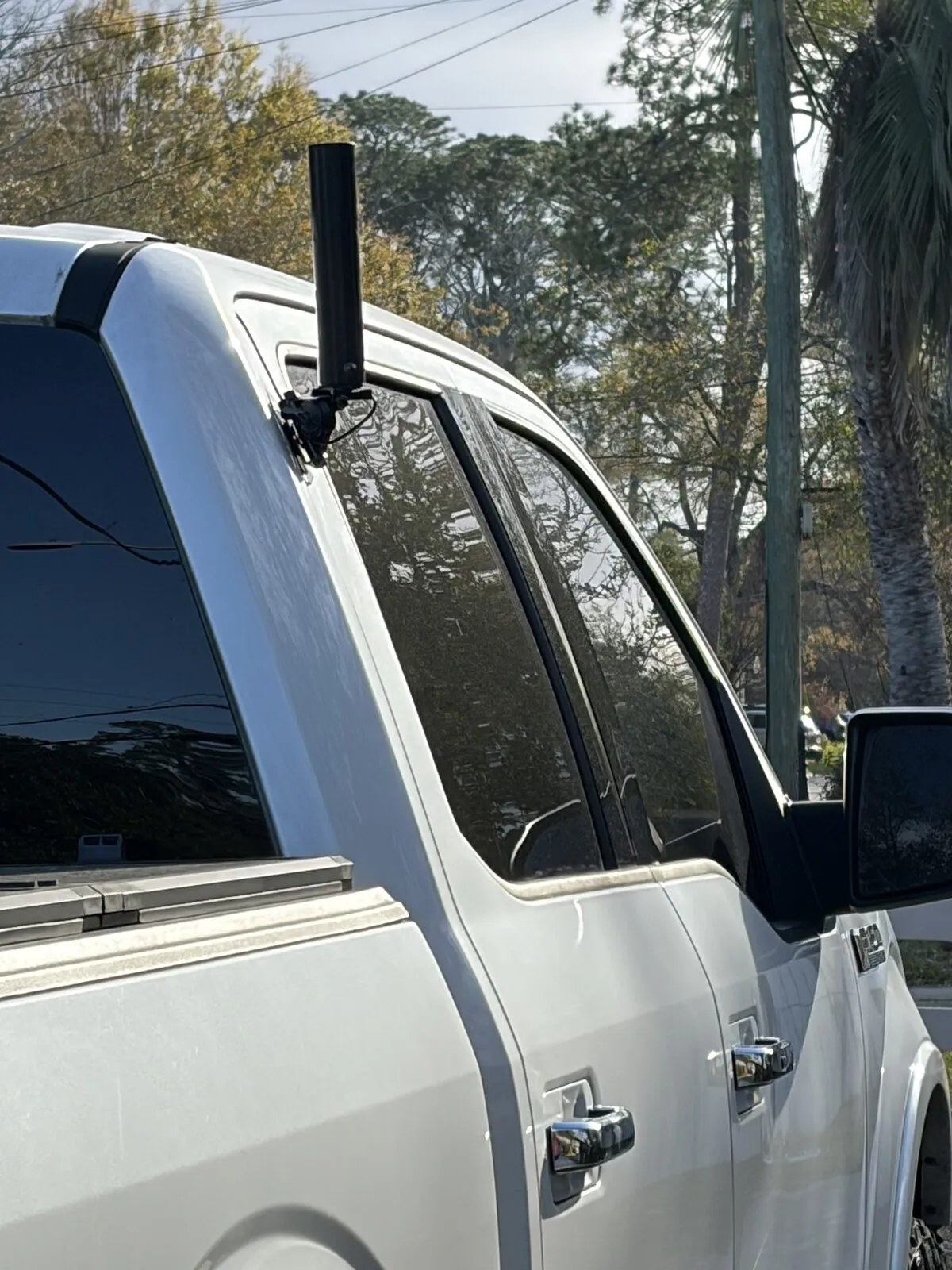 The 7.5 inch dual-band antenna standing on the Comet NMO bracket at the top rear corner of the rear passenger door.
