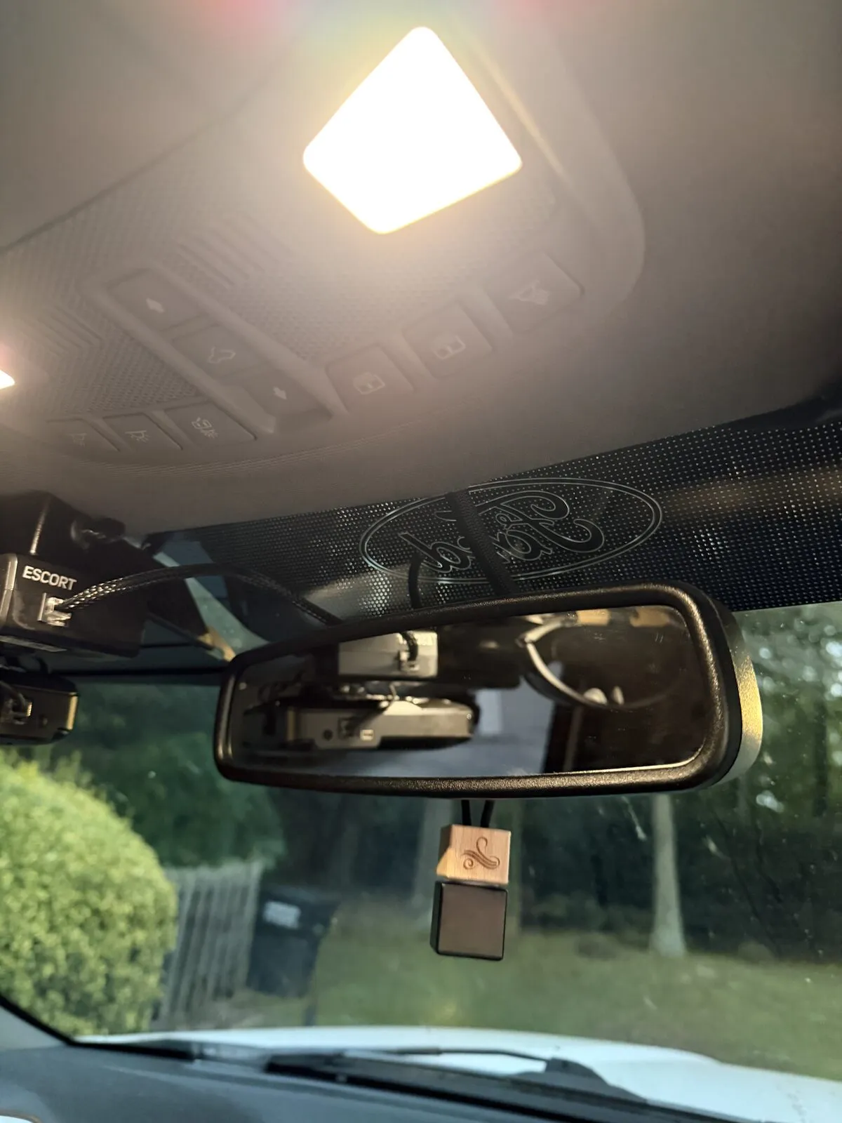 Looking up at the overhead console, the dome light and the rearview mirror from the driver seat.