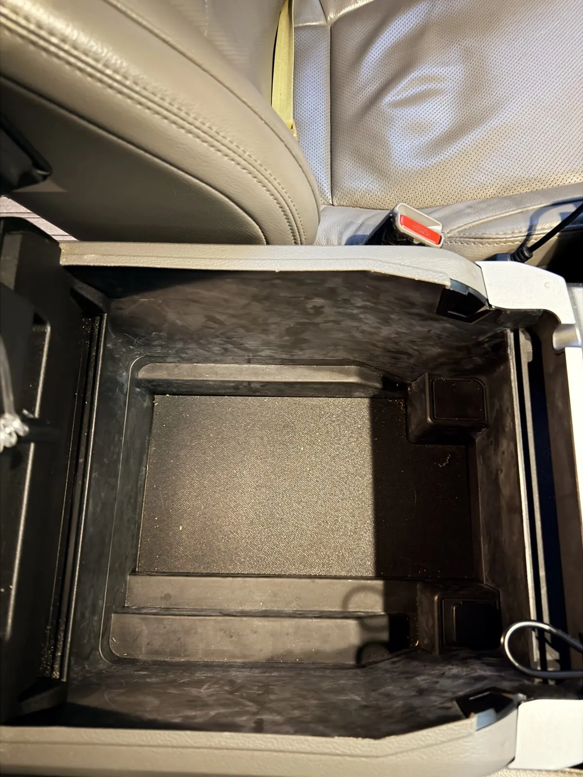 Looking straight down into the empty center console armrest bin.