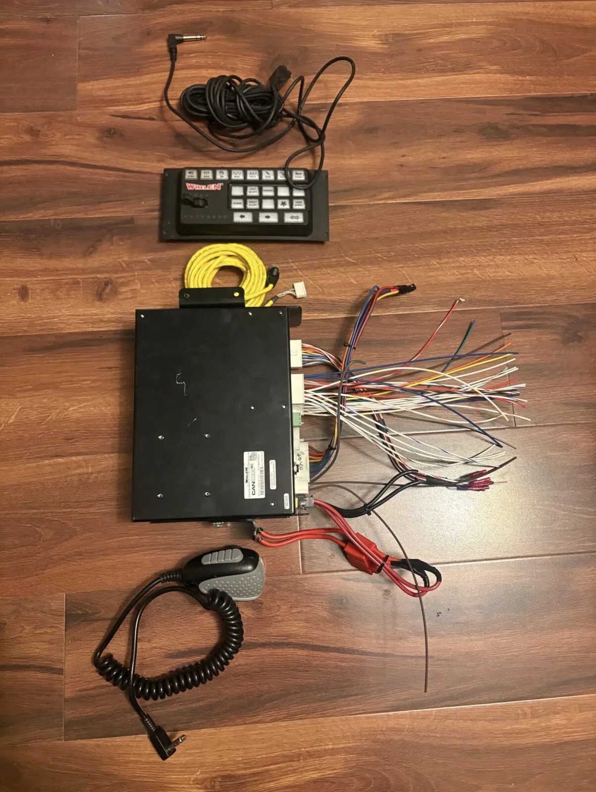 The complete set laid out top to bottom: mic extension, control head, yellow head cable, module with harness, and the PA microphone.
